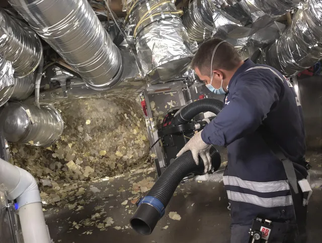 Norwell Air Duct Cleaning specialist operating negative pressure cleaning equipment for thorough duct maintenance in Norwell